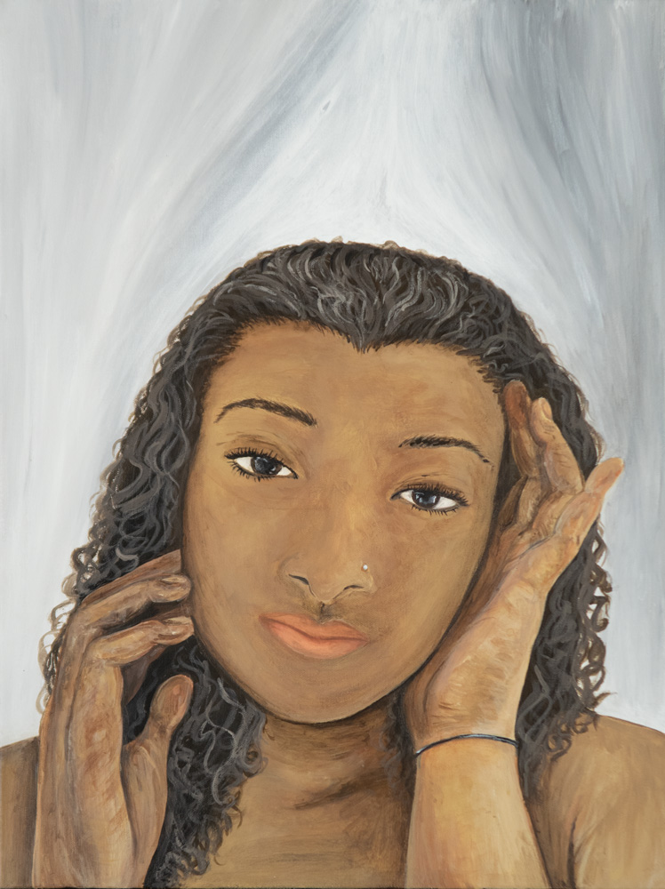 A young african american woman stares a the viewer with her hands gently touching the sides of her face.